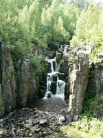 Ступенчатый каскад Уковского водопада продолжается небольшим озером и глубоким каньоном, загроможденным огромными камнями. Особую зрелищность водопаду придает высокая, похожая на средневековую башню каменная скала справа от него, усеянная пещерами-бойницами.  | Нижнеудинск